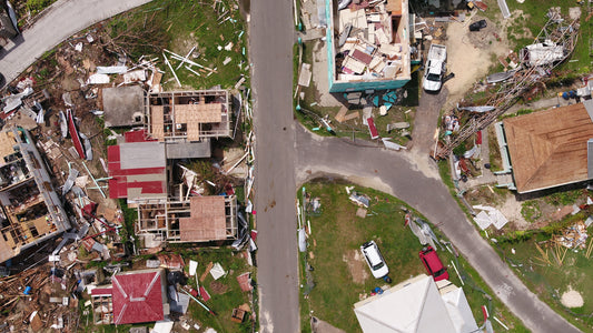 Top down view of the after math of a destructive hurricane. Houses seen with their roofs torn apart, debris seen everywhere.