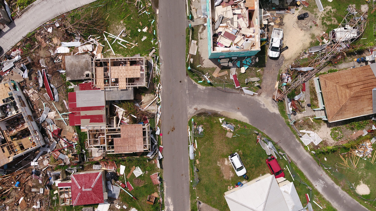 Aerial view of a neighborhood with damaged houses after a disaster.