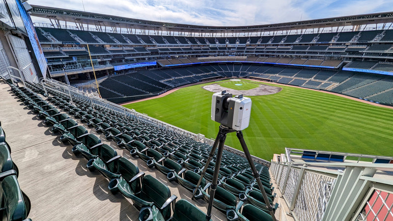 Stadium with green seats and a scanner on a tripod facing the field